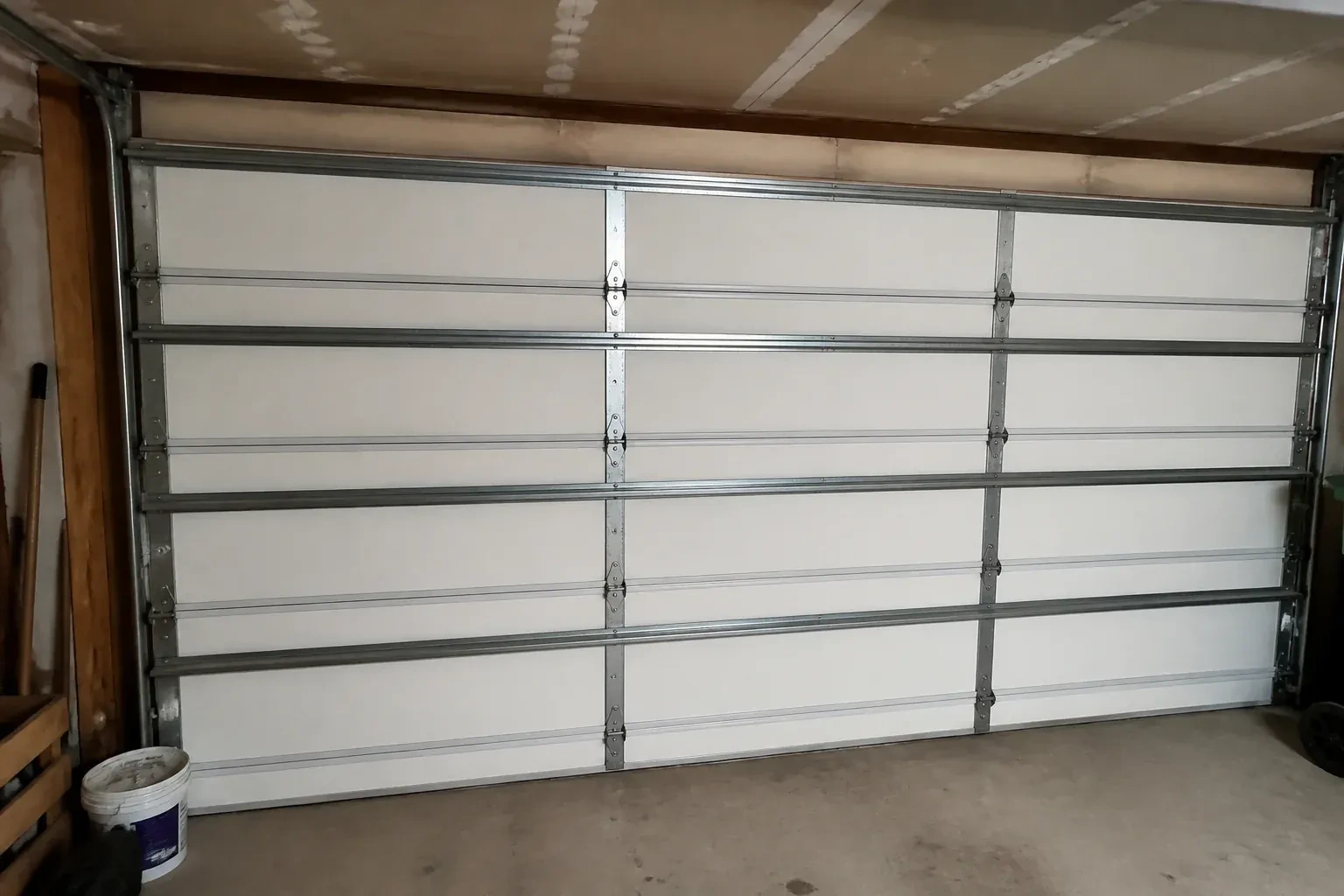 Interior of a closed sectional door with horizontal metal reinforcement struts. — Wind-Rated Garage Door Replacement, Burlington